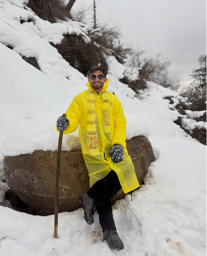 Standing on a snowy mountain in a yellow jacket